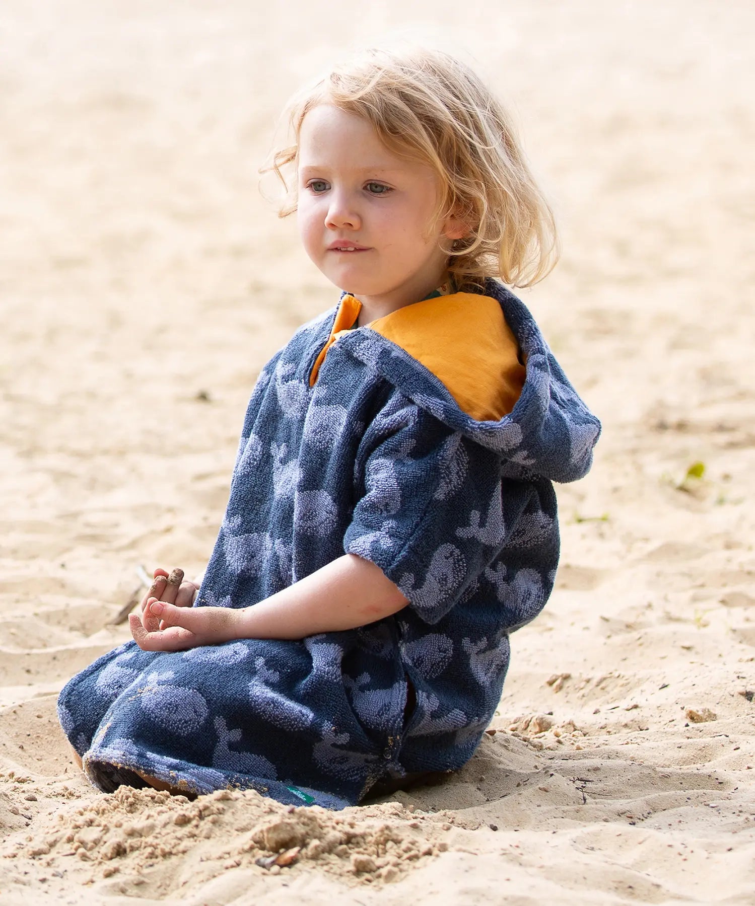 Child wearing the Little Green Radicals clue singing whale kids organic cotton towel poncho. 