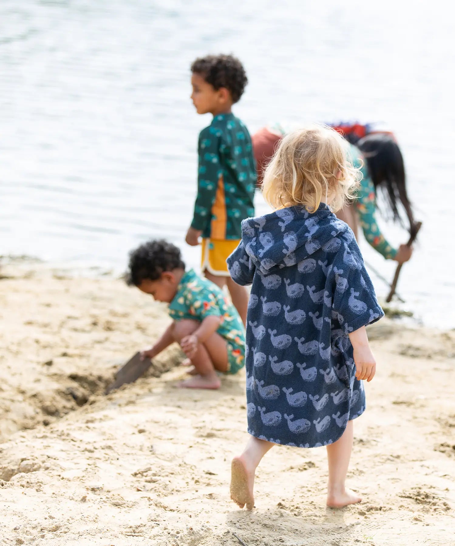 Back of a child wearing the Little Green Radicals clue singing whale kids organic cotton towel poncho. 