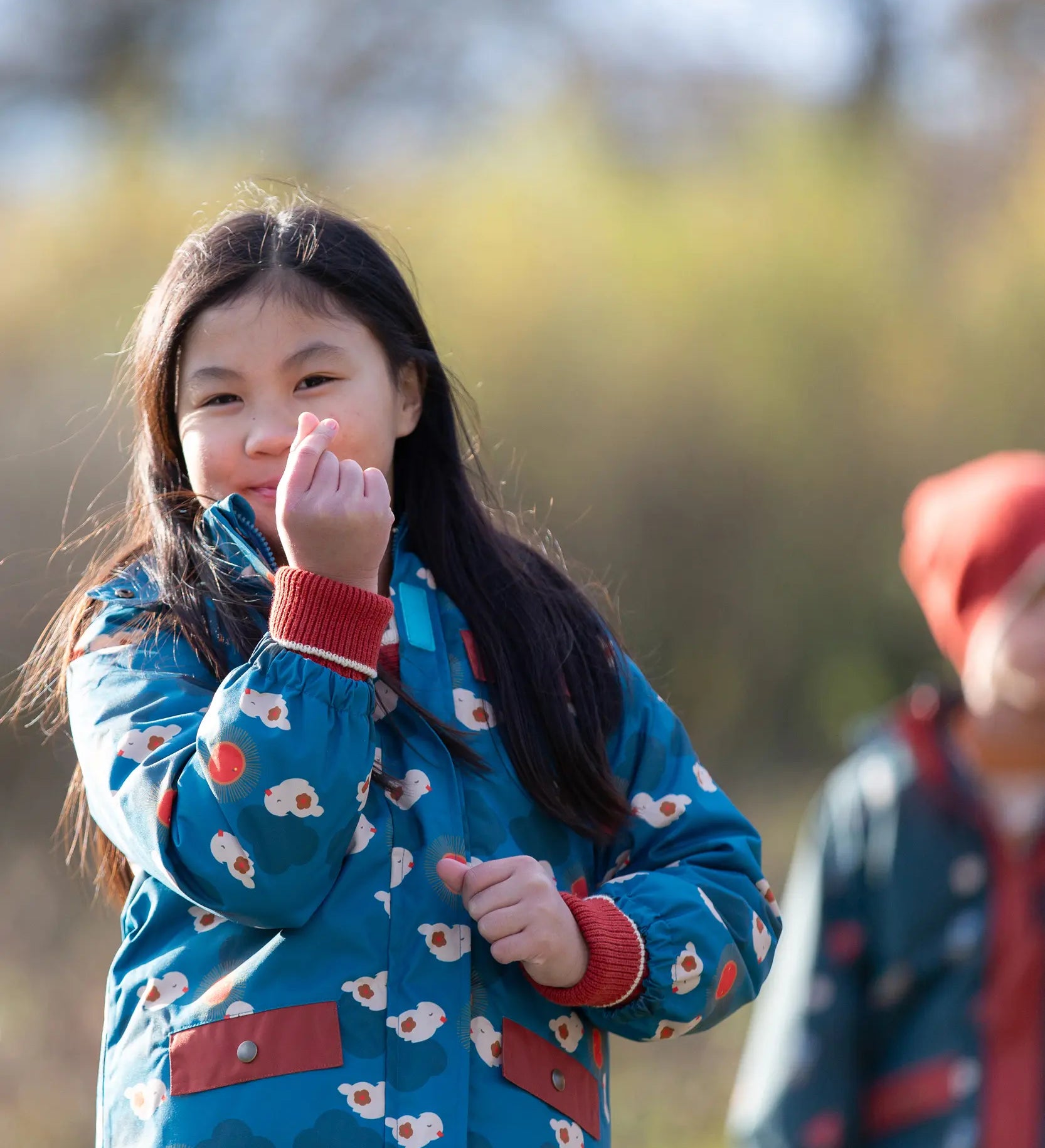 Child wearing a Little Green Radicals blue sun birds recycled waterproof adventure Winter coat.