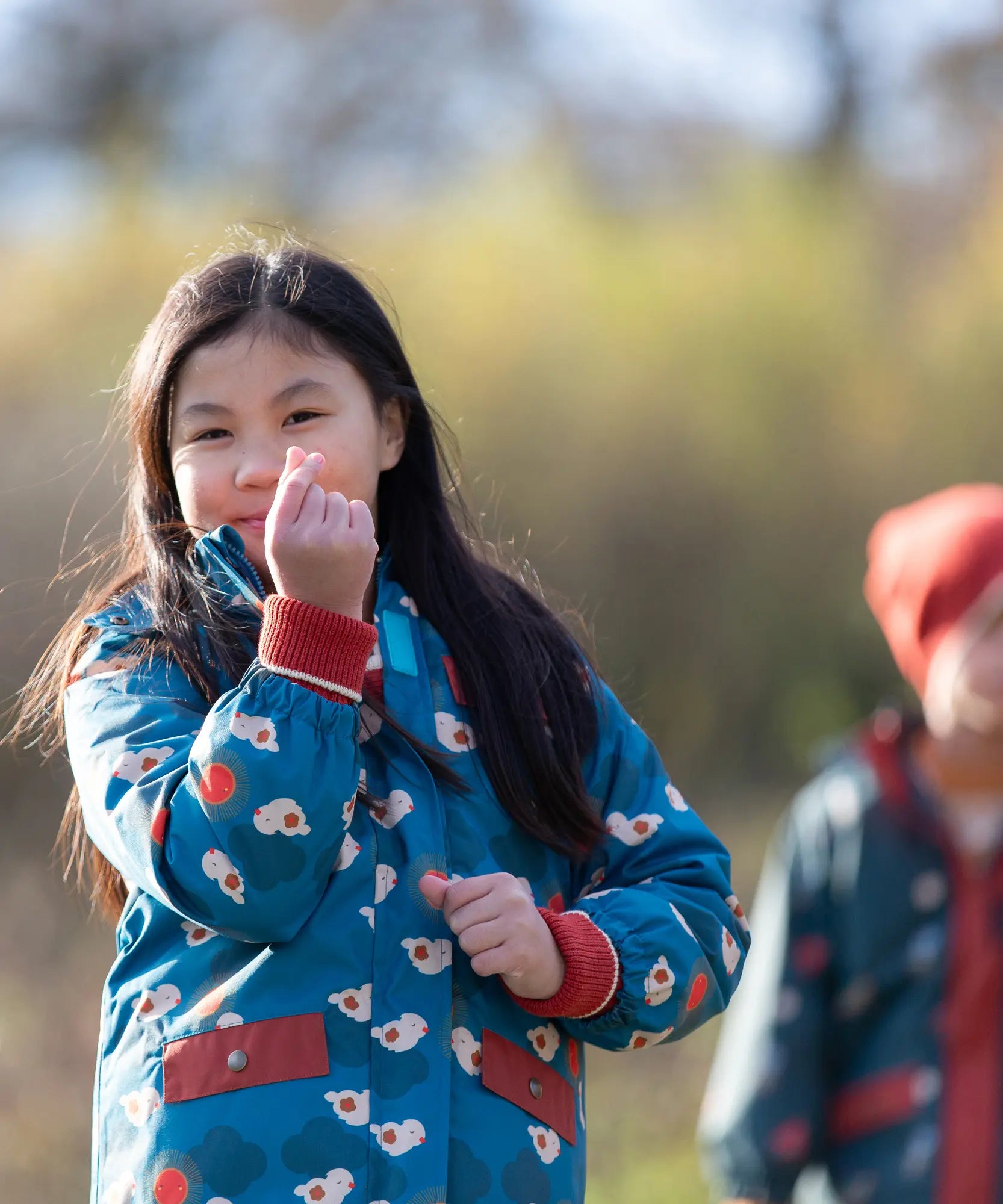 Child wearing a Little Green Radicals blue sun birds recycled waterproof adventure Winter coat.