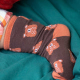 A close up of the Little Green Radicals brown teddy bear organic cotton socks on a child's feet. These socks are part of a wide range of organic cotton clothing and accessories for children available here at Babipur. 