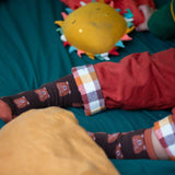 A close up of the Little Green Radicals brown teddy bear organic cotton socks on a child's feet. These socks are part of a wide range of organic cotton clothing and accessories for children available here at Babipur. 