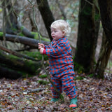 Child wearing the Little Green Radicals burnt ochre check classic pyjamas with green wellingtons.