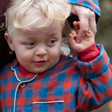 Child wearing the Little Green Radicals burnt ochre check classic pyjamas.