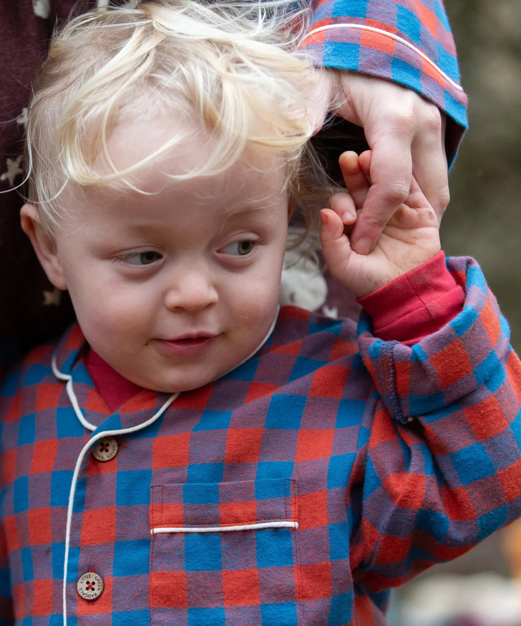 Child wearing the Little Green Radicals burnt ochre check classic pyjamas.