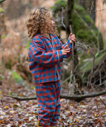 Child wearing the Little Green Radicals burnt ochre check classic pyjamas with yellow gold wellingtons.