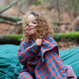 Child wearing the Little Green Radicals burnt ochre check classic pyjamas.