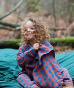 Child wearing the Little Green Radicals burnt ochre check classic pyjamas.