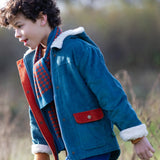 Child wearing a Little Green Radicals calm sea colourblock organic cotton sherpa lined toasty coat with scarf.