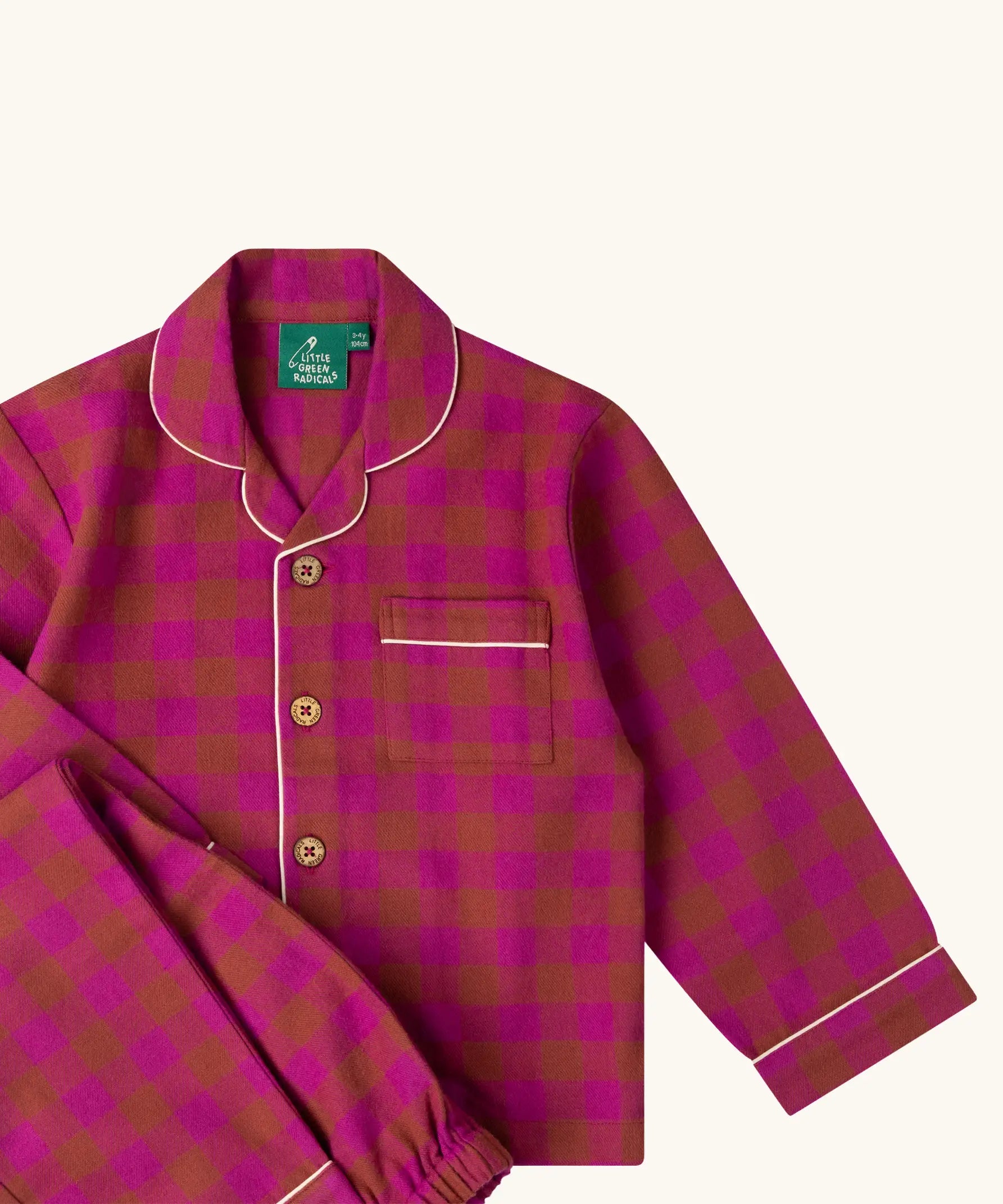 Close up of the Little Green Radicals Kids berry pink check organic cotton classic pyjamas. Button up long sleeve top and matching trousers. 