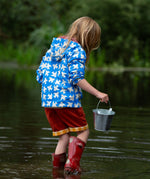 A child wearing the Little Green Radicals Diving And Splashing Blue Recycled Waterproof Kids Packable Anorak, facing away from the camera showing the back of the jacket.