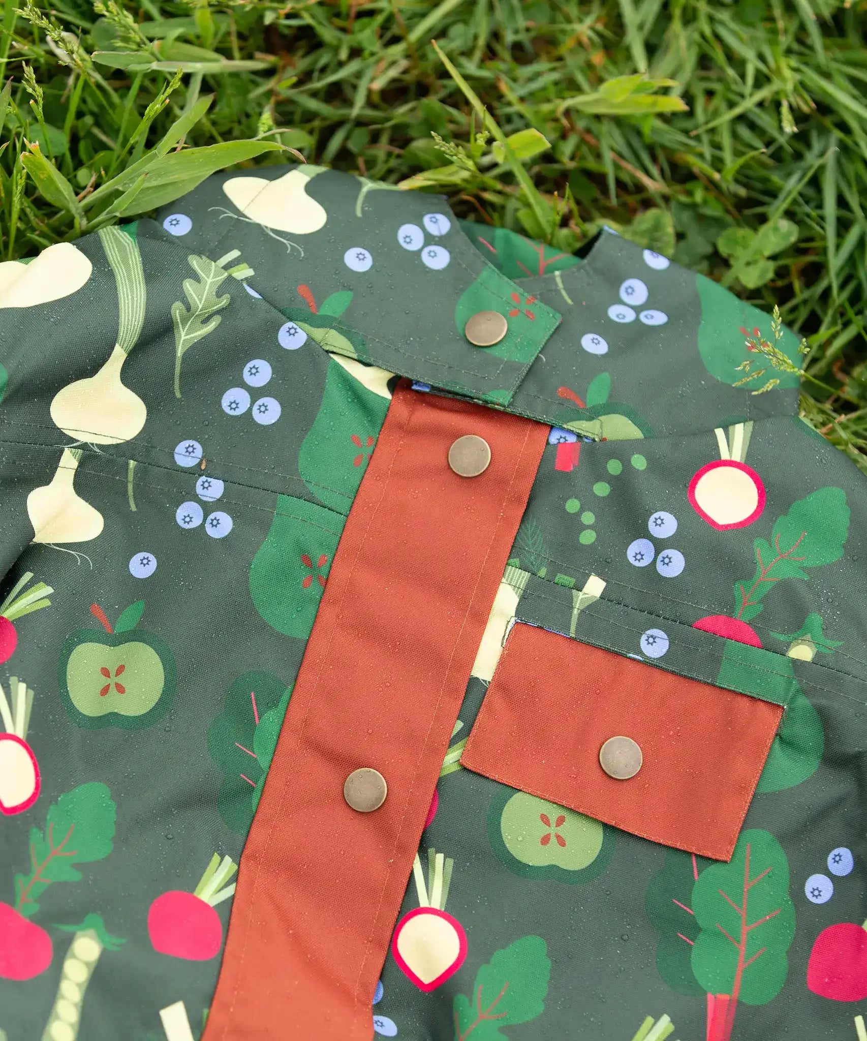 Dark gold coloured buttons on the front of the Little Green Radicals feast waterproof recycled kids raincoat.