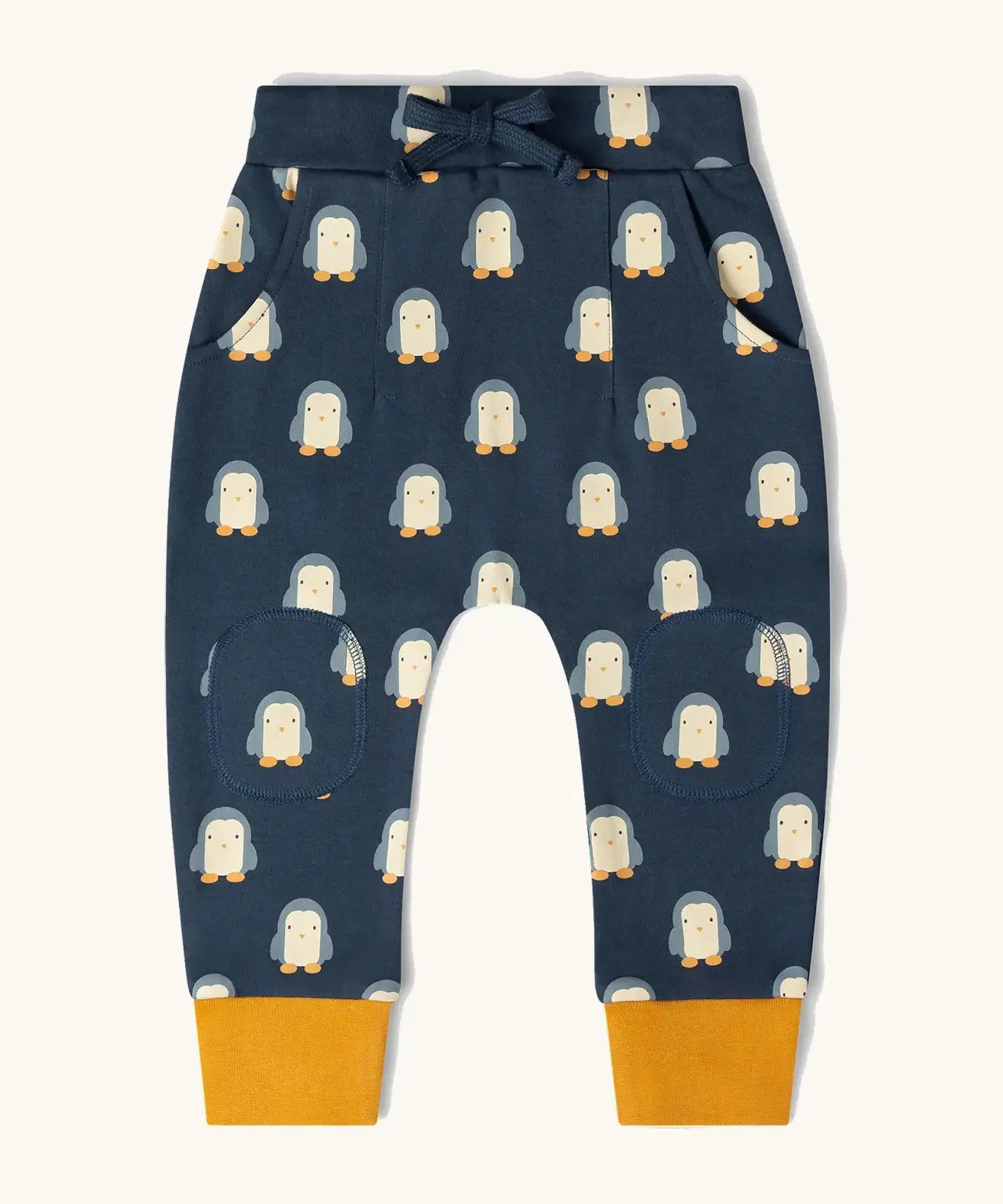 Little Green Radicals organic cotton comfy joggers with a blue penguins design and yellow leg cuffs.