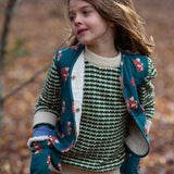 A child wearing the Little Green Radicals Children's Sherpa Fleece Gilet in the red foxes design. This gilet is a part of a wide range of organic cotton clothing for children available here at Babipur. 