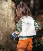 A child wearing the Little Green Radicals Children's Sherpa Fleece Gilet in the red foxes design. This gilet is a part of a wide range of organic cotton clothing for children available here at Babipur. 