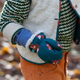 A close up of a child's hand, the child is wearing the Little Green Radicals fox print sherpa fleece lined mittens. The children's sized mittens are part of a wide range of organic cotton clothing for children available here at Babipur. 
