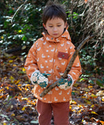 A child holding a stick wearing the  Little Green Radicals Hedgerow print Children's Sherpa Lined Mittens and a duck print coat. 