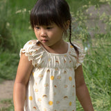 A close up of a A child wearing the Little Green Radicals Sunshine & Rainbows Pocket Playdays Dress. Little green Radicals have a wide range of organic cotton, Fairtrade children's clothing and outerwear available here at Babipur.