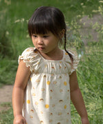 A close up of a A child wearing the Little Green Radicals Sunshine & Rainbows Pocket Playdays Dress. Little green Radicals have a wide range of organic cotton, Fairtrade children's clothing and outerwear available here at Babipur.
