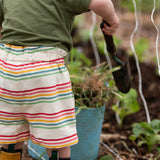 Back of the Little Green Radicals children's cream rainbow striped by the sea twill shorts being worn.