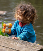 A child wearing the Little Green Radicals From One To Another Deep Blue Colour Block Knitted Cardigan. This organic cotton cardigan is part of a wide range of organic cotton, Fairtrade children's clothing and outerwear available here at Babipur.