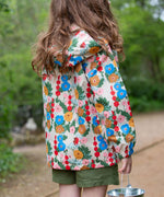 Little Green Radicals Child's Flora & Fauna vintage style flower print Waterproof Raincoat. The child is facing away from the camera showing a view of the back of the jacket.