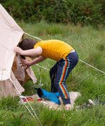 A child wearing the Little Green Radicals Navy Rainbow Stripe Organic Comfy Joggers with a yellow short sleeved t-shirt.