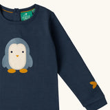 Close up of the Little Green Radicals blue penguins applique long sleeve organic cotton top in navy.