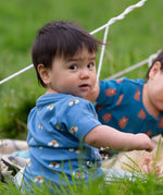 A child wearing the Little Green Radicals Kids' Organic T-shirt and Joggers Playset outfit in the  Blue Rainbows design. 