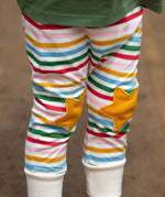 A close up of a child's legs wearing the Little Green Radicals Stars Knee Patch Rainbow Striped Children's Organic Cotton Joggers