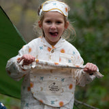 A child wearing the Little Green Radicals moon and sun classic pyjama set. A GOTS organic cotton pyjama set including a long sleeve shirt style top in light pink with prints of cute birds flying through stars the moon and sun also includes matching bottoms. These pyjamas are part of a wide range of organic cotton clothing for children available here at Babipur.