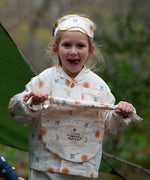 A child wearing the Little Green Radicals moon and sun classic pyjama set. A GOTS organic cotton pyjama set including a long sleeve shirt style top in light pink with prints of cute birds flying through stars the moon and sun also includes matching bottoms. These pyjamas are part of a wide range of organic cotton clothing for children available here at Babipur.