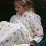 A child wearing the Little Green Radicals moon and sun classic pyjama set. A GOTS organic cotton pyjama set including a long sleeve shirt style top in light pink with prints of cute birds flying through stars the moon and sun also includes matching bottoms. These pyjamas are part of a wide range of organic cotton clothing for children available here at Babipur.