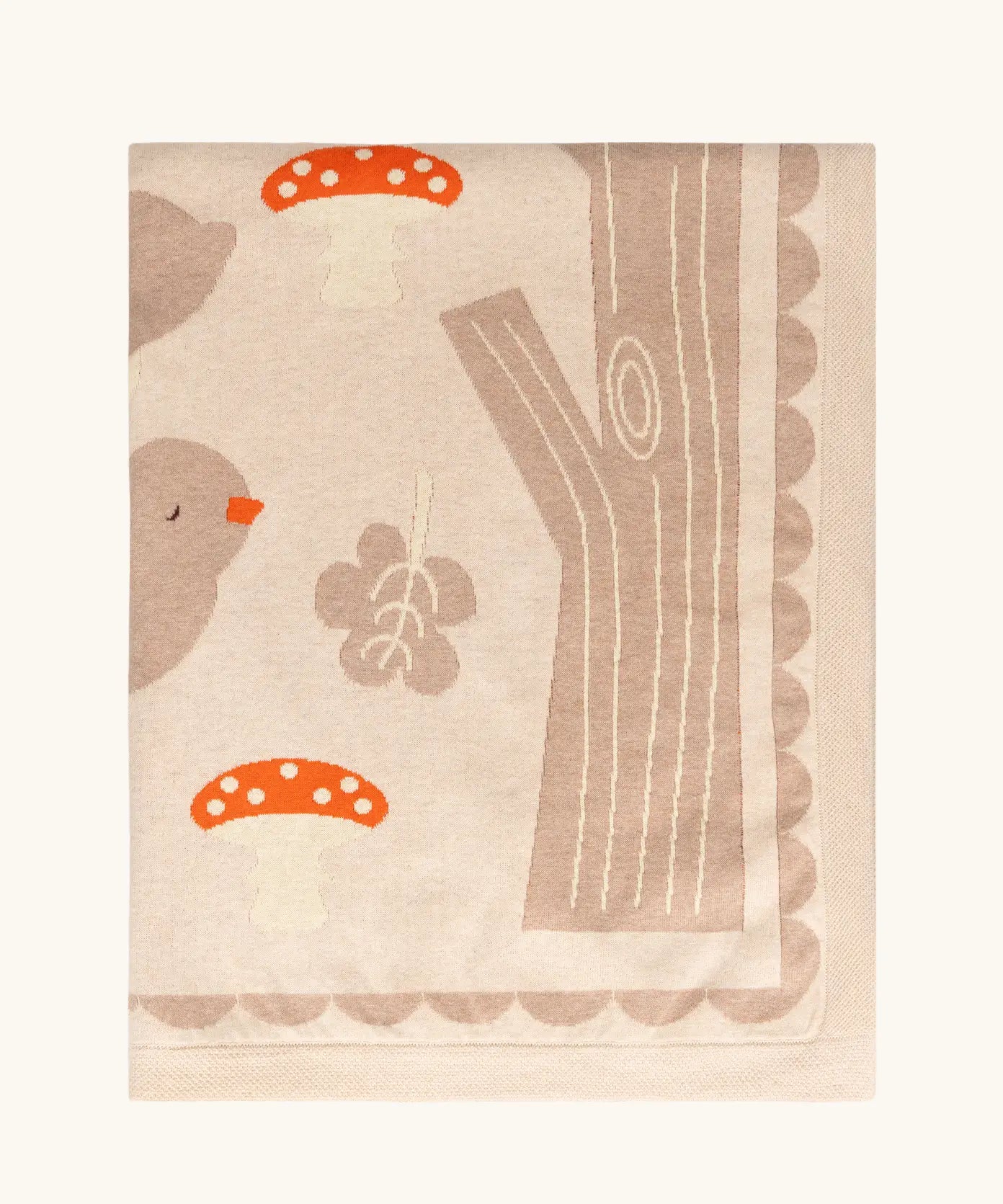Little Green Radicals cream folk tales knitted organic cotton baby blanket shown folded.