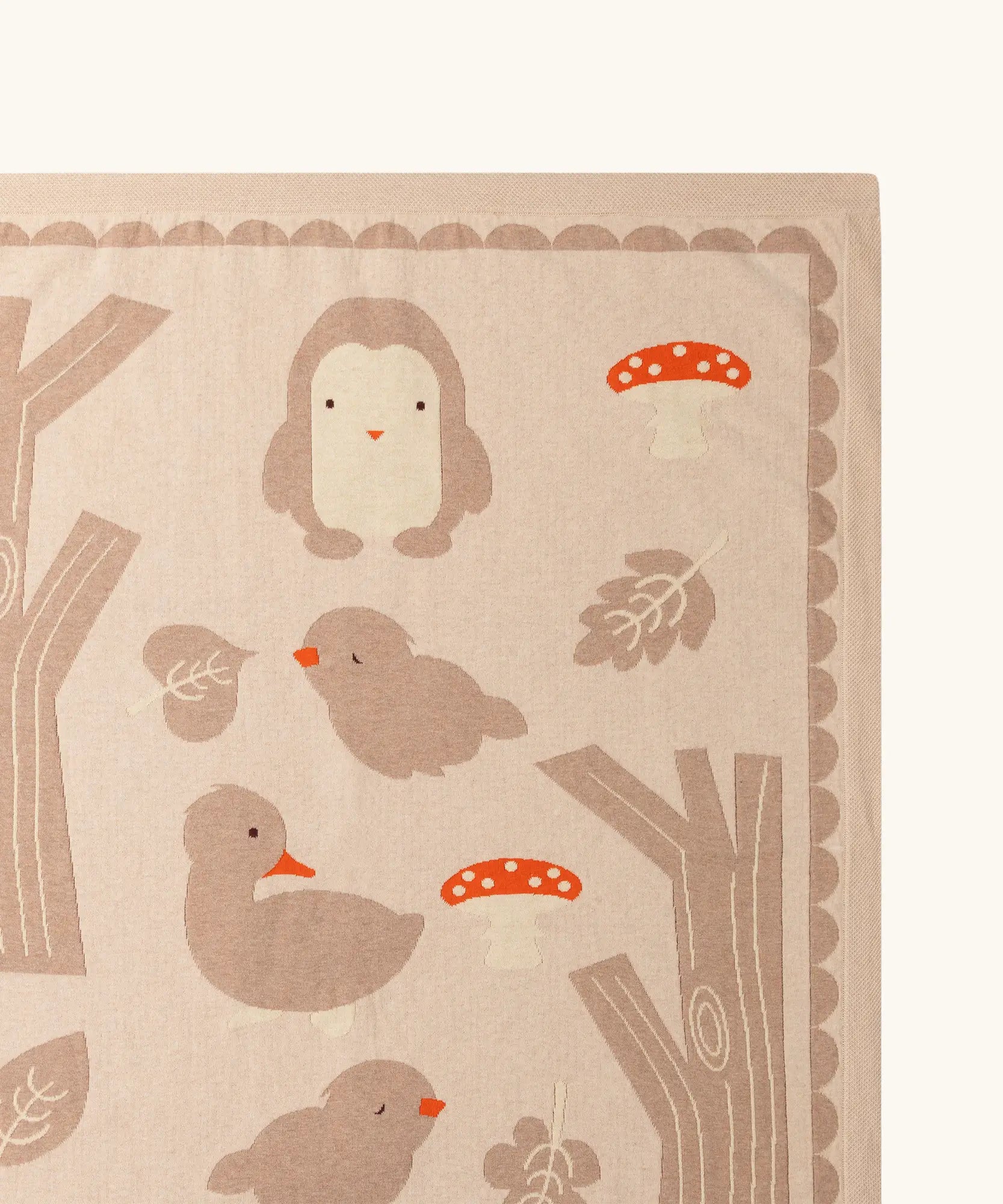 Close up of the Little Green Radicals cream folk tales knitted organic cotton baby blanket