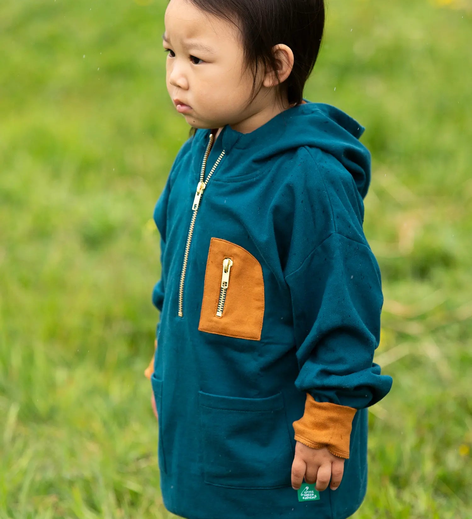 Child wearing a Little Green Radicals children's atlantic deep blue organic cotton quarter zip hoodie.