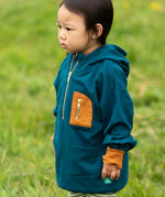 Child wearing a Little Green Radicals children's atlantic deep blue organic cotton quarter zip hoodie.