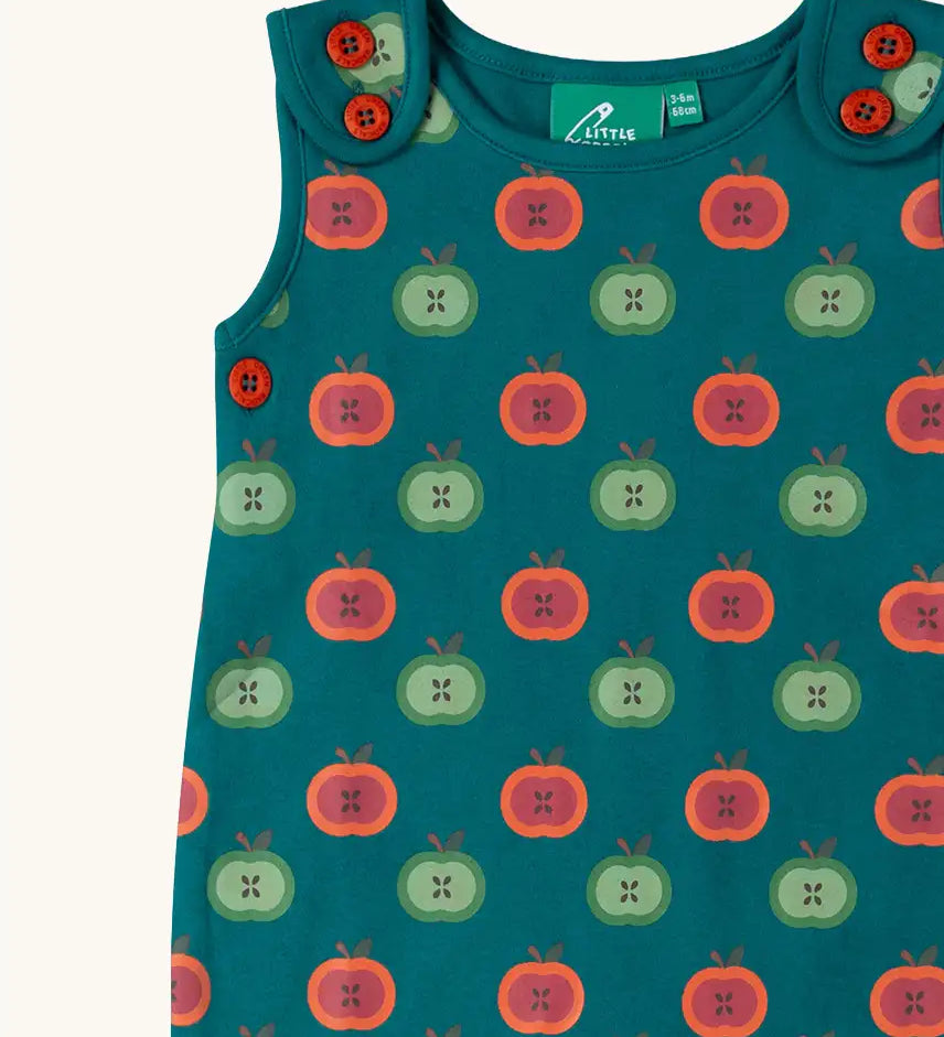 Close up of the red and green repeat apple print on the Little Green Radicals apple picking everyday organic cotton dungarees.