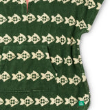 Material of the Little Green Radicals swimming fish organic cotton hooded towel poncho. Cream fish pattern on a green background.