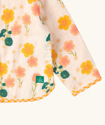 Close up of the Little Green Radicals children's Flora Reversible Spring Jacket with yellow gingham print binding on edges.
