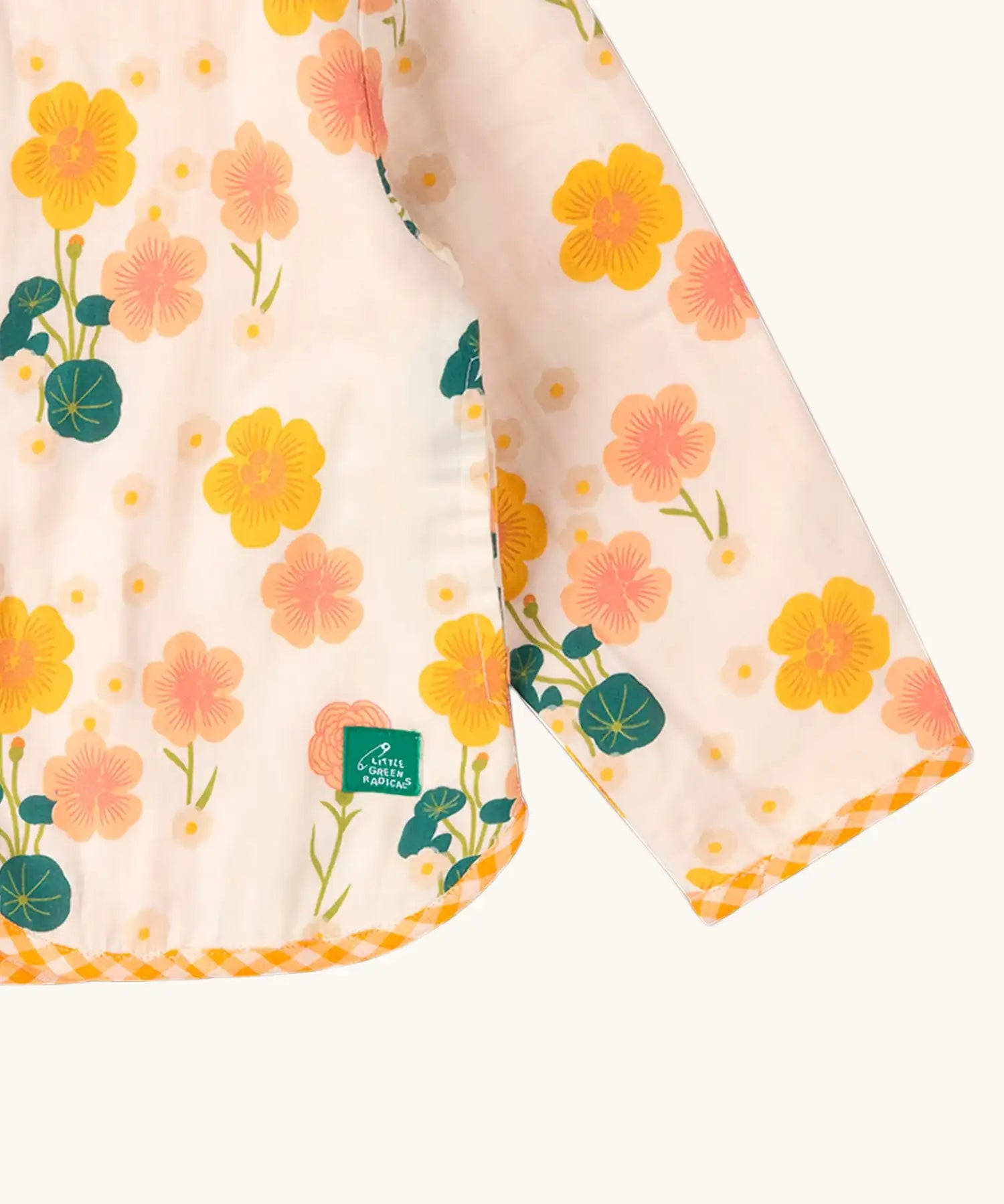Close up of the Little Green Radicals children's Flora Reversible Spring Jacket with yellow gingham print binding on edges.