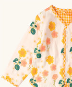 Close up of the Little Green Radicals children's Flora Reversible Spring Jacket in cream with yellow gold gingham print edging. 