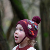 Child wearing the Little Green Radicals folk birds knitted purple bobble hat.