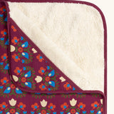 Close up of the Little Green Radicals folk bird organic cotton hooded baby blanket with sherpa fleece lining.
