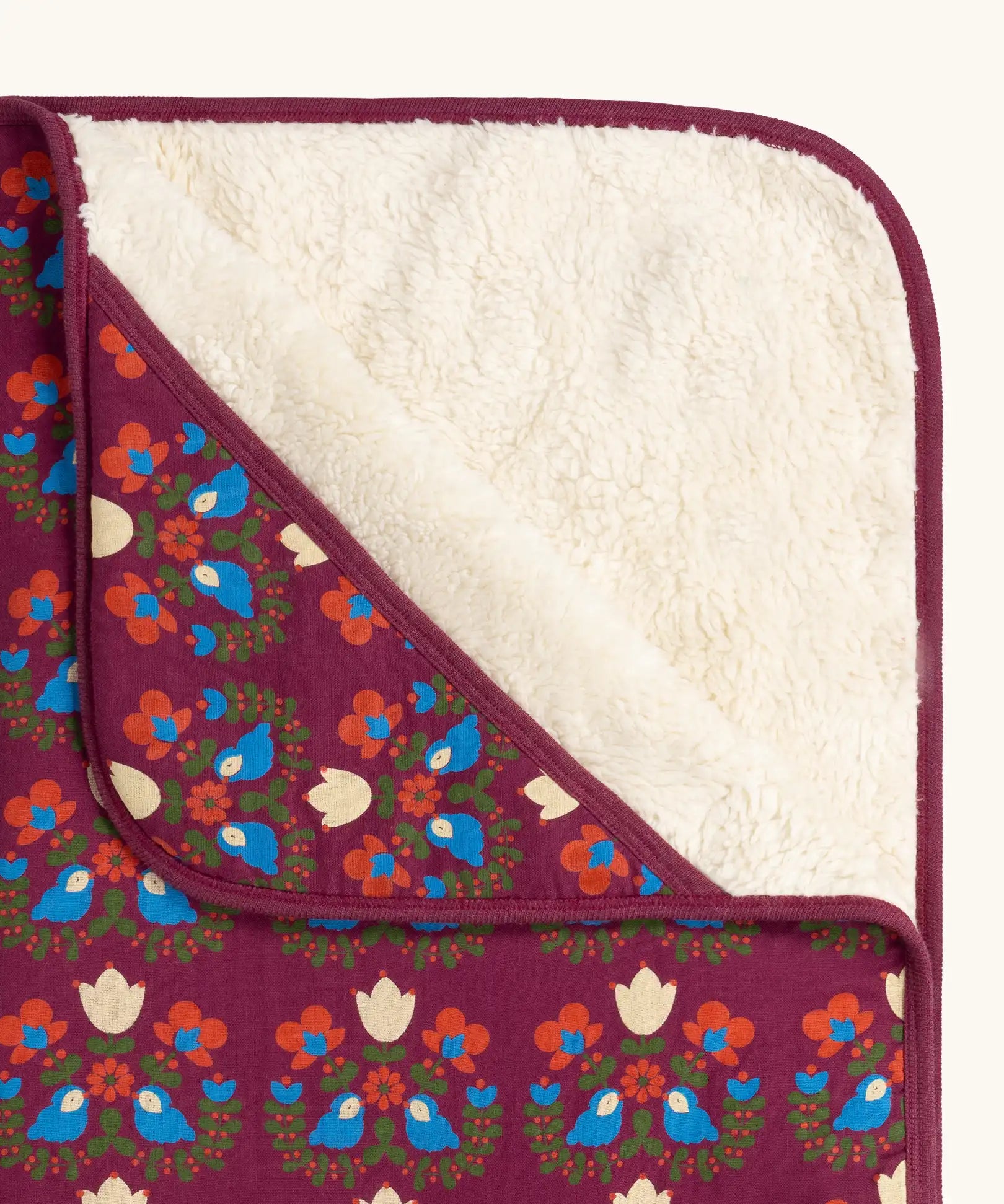 Close up of the Little Green Radicals folk bird organic cotton hooded baby blanket with sherpa fleece lining.