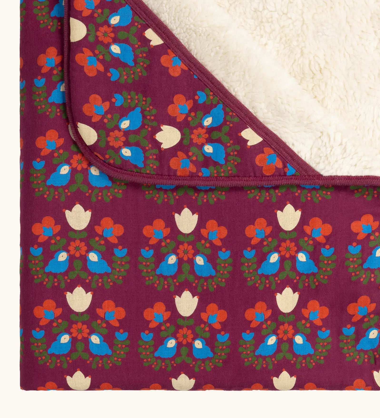 Close up of the Little Green Radicals folk bird organic cotton hooded baby blanket with sherpa fleece lining.