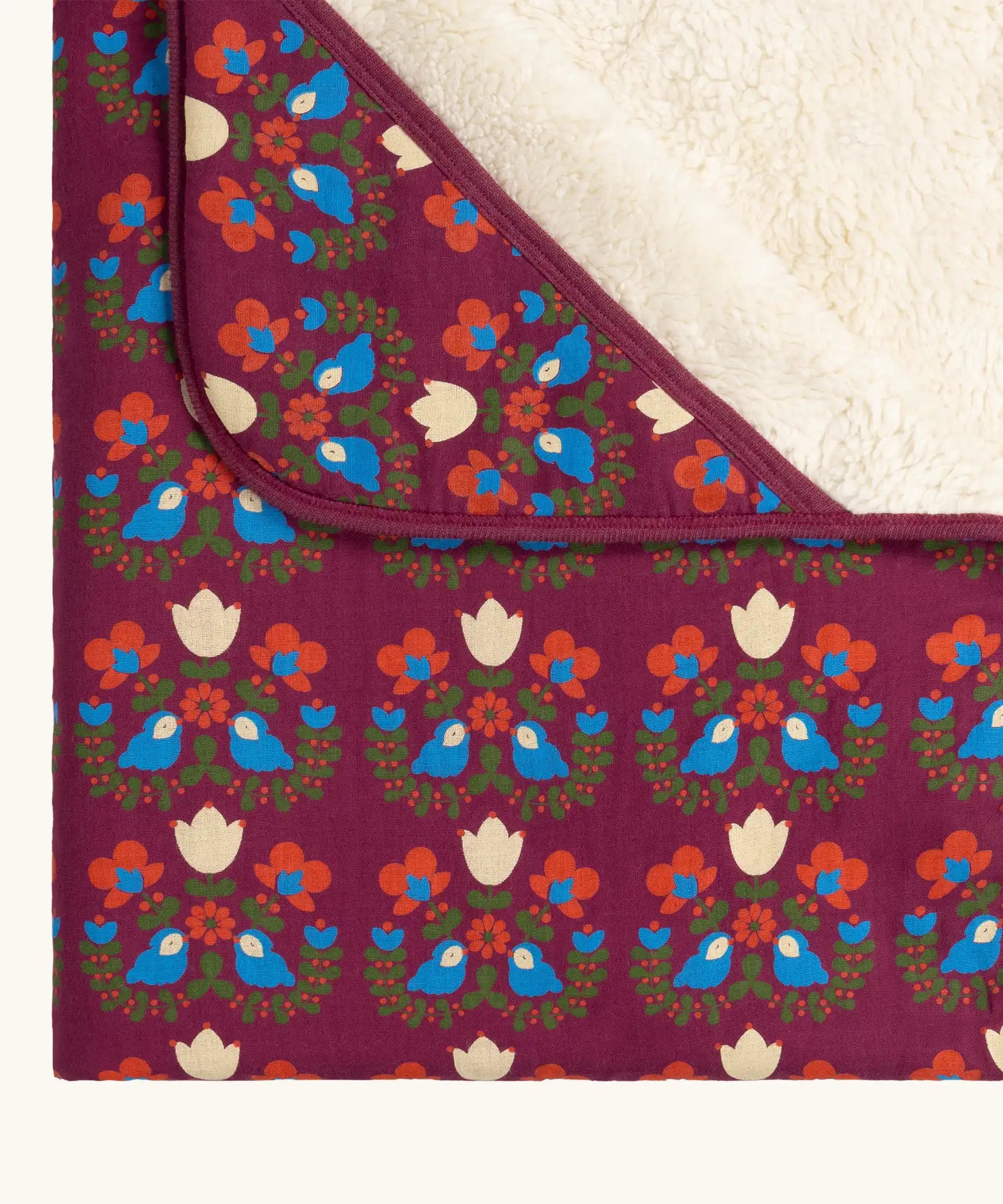 Close up of the Little Green Radicals folk bird organic cotton hooded baby blanket with sherpa fleece lining.