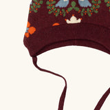 Close up showing the chin tie straps on the Little Green Radicals folk birds knitted purple bobble hat.