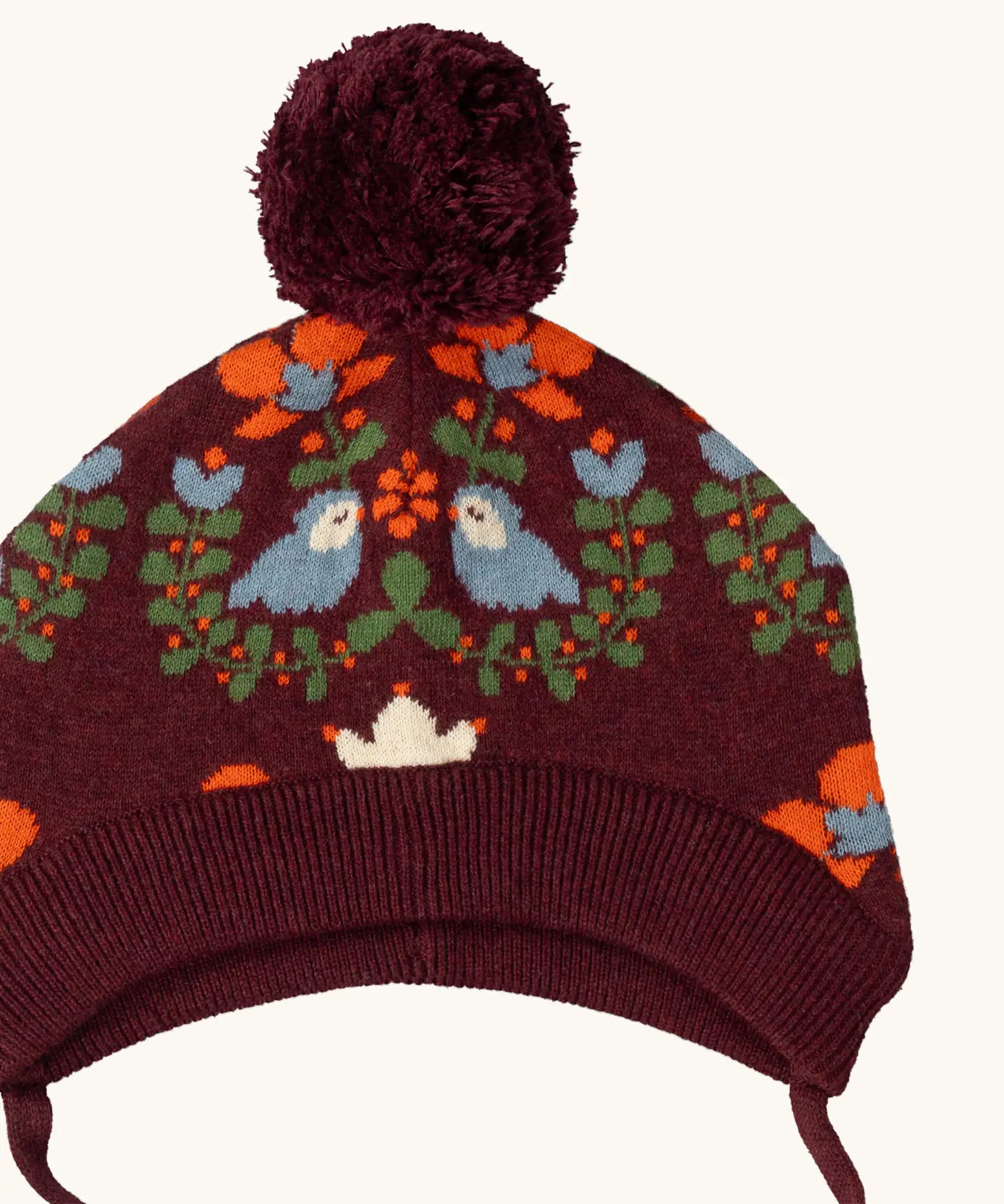 Little Green Radicals folk birds knitted purple bobble hat, close up showing the details on the design