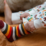 Child wearing the rainbow striped socks from the Little Green Radicals folk tales ankle socks 3 pack.